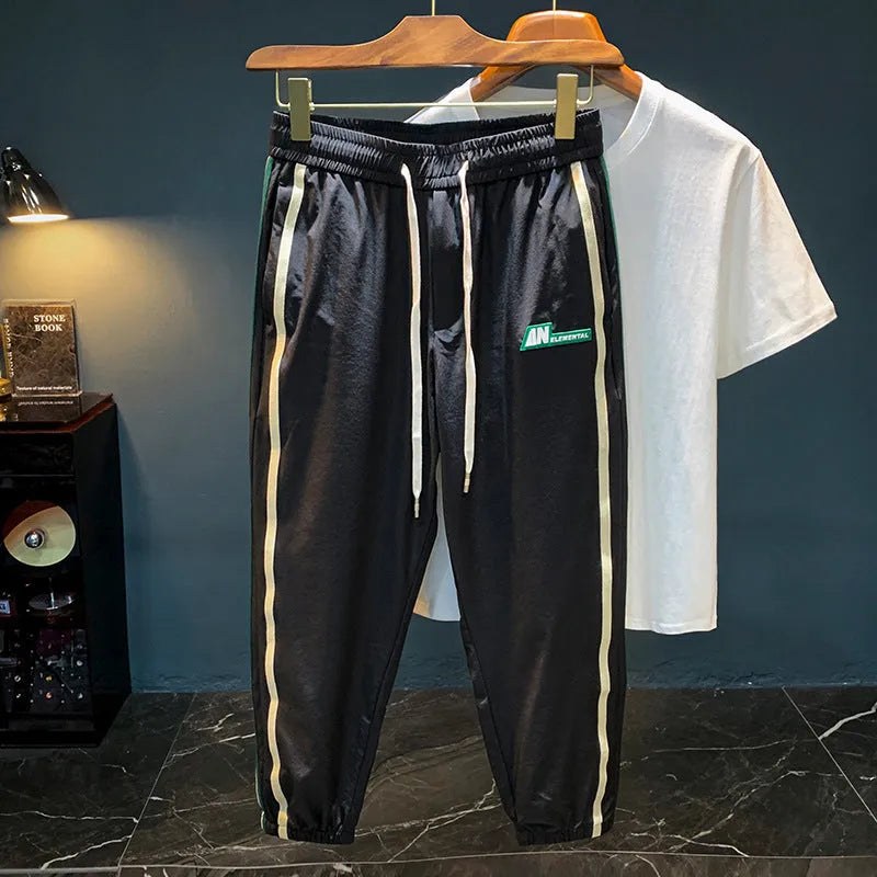 Men's solid black cotton harem pants laid flat, showing relaxed fit and mid waist design.