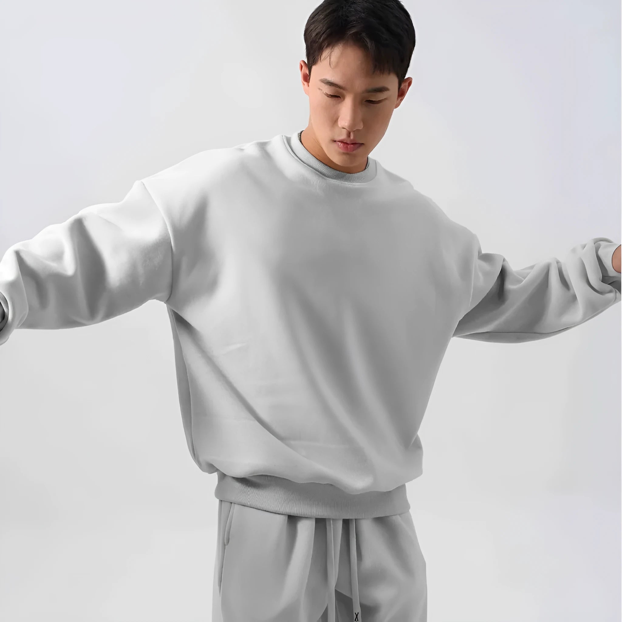 Man wearing a loose-fit black polar fleece jacket and matching trousers, a two-piece winter sports suit.