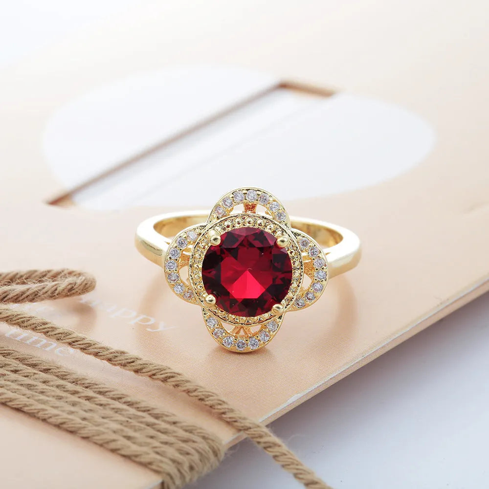 Close-up of a fruit-shaped copper ring with an electroplated finish and an inlaid zircon, shown on a hand.