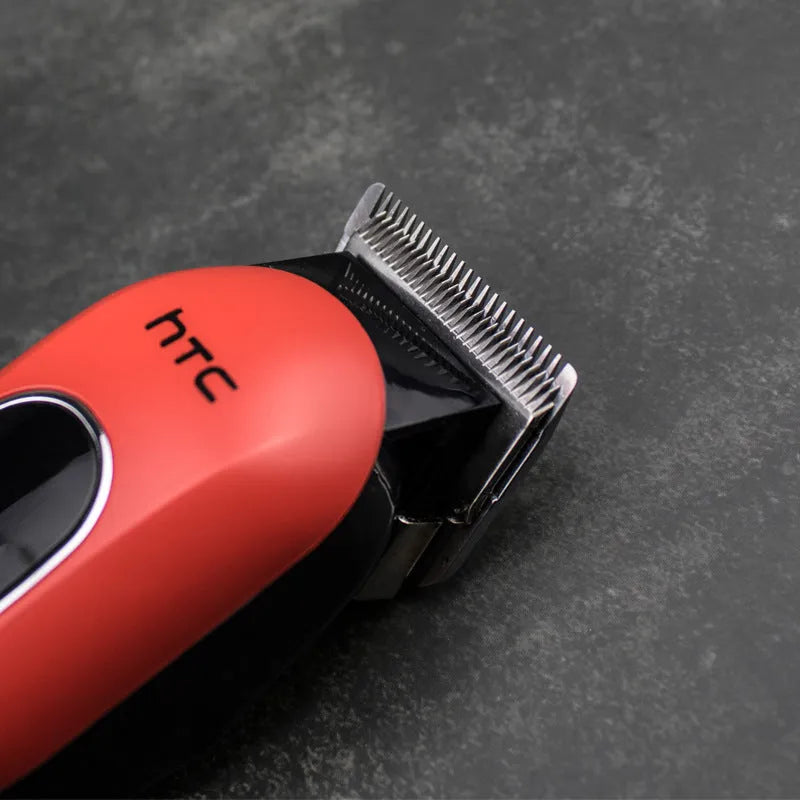 Black digital hair clipper with four plastic limiting combs and a bottle of oil on a white background.