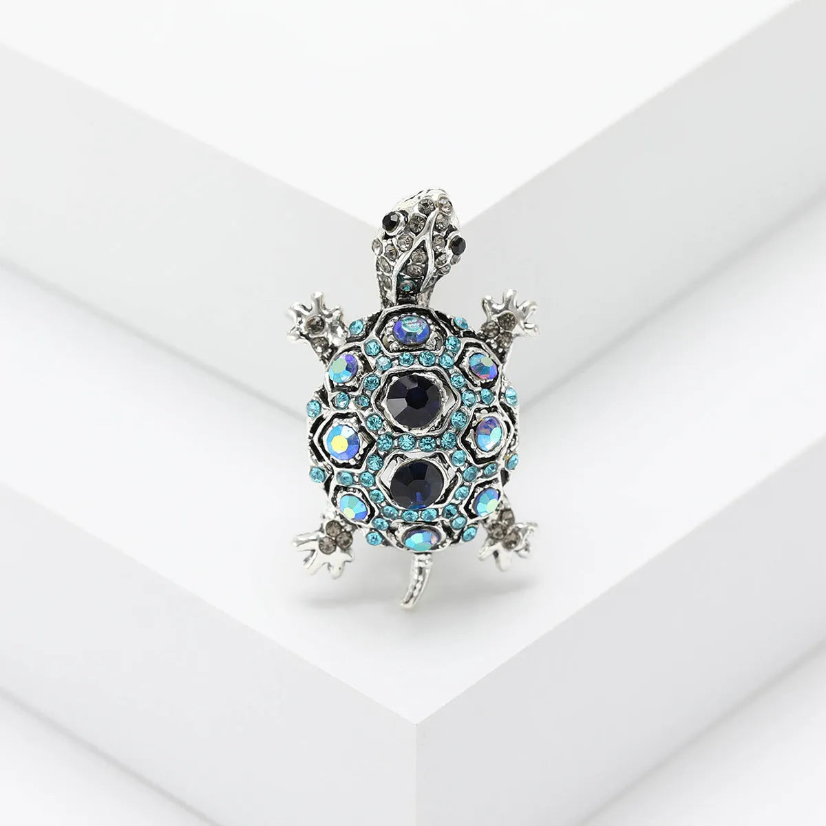 Fashion retro rhinestone turtle brooch in green on a textured surface