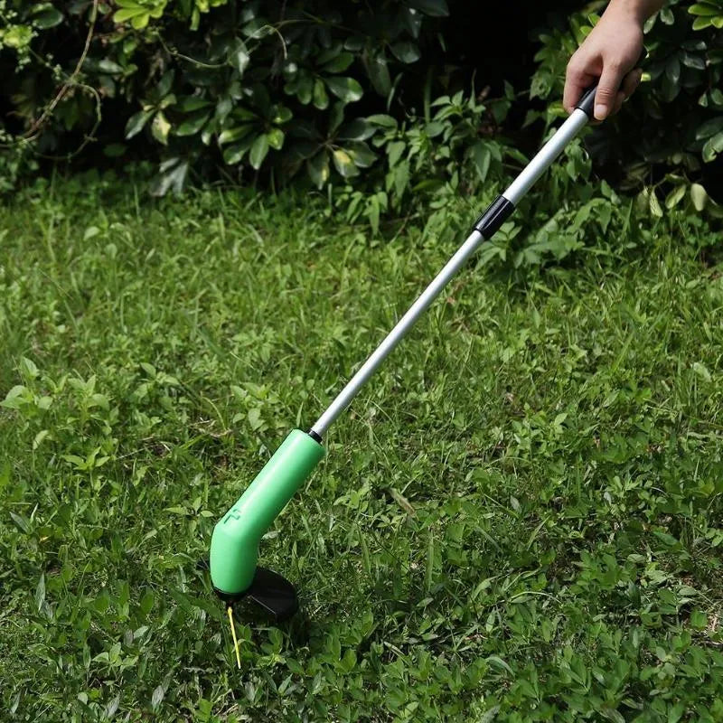 Cordless lawn trimmer with lightweight extension pole and protective debris shield on grass