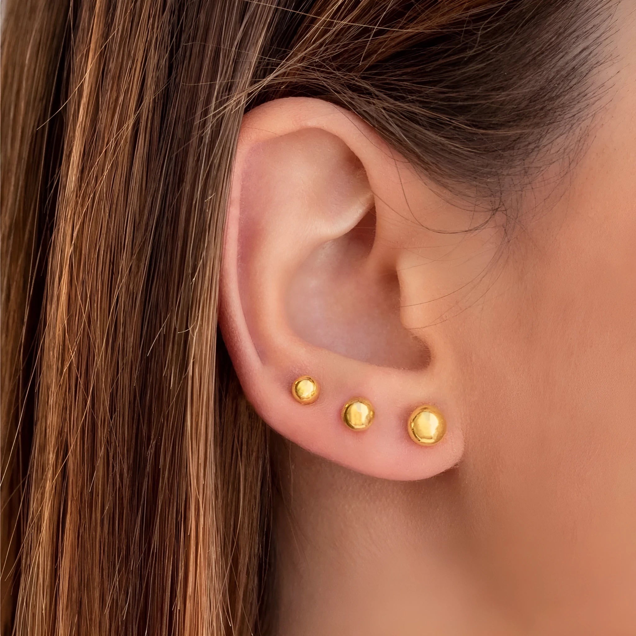 Stainless steel 18K gold ball stud earrings in simple round geometric design on a white background.
