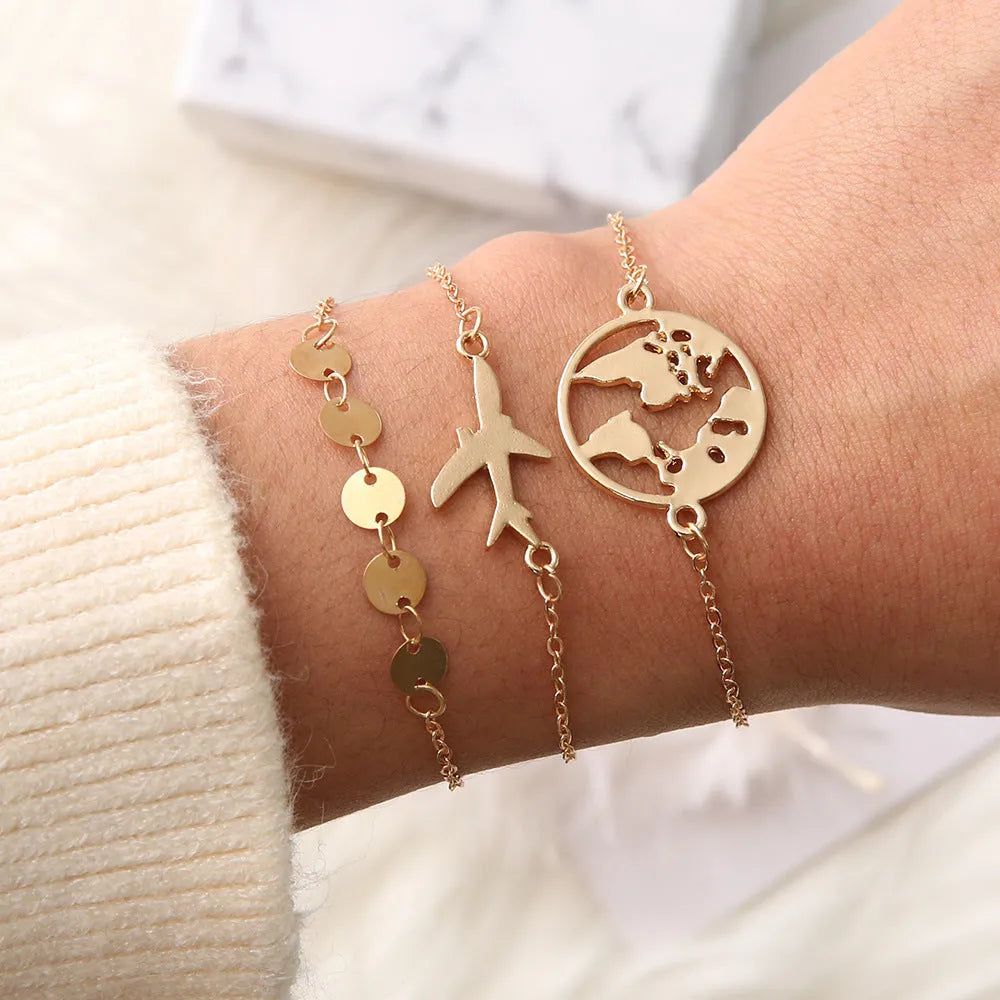Three identical women's alloy charm bracelets with heart-shaped aircraft map charm on a white background.