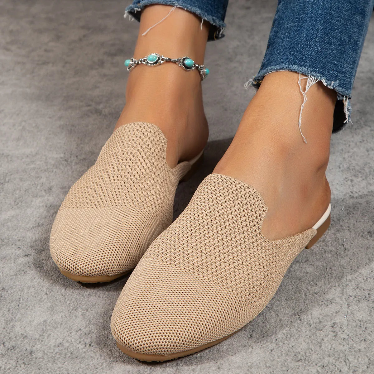 A pair of apricot-coloured mesh slip-on sandals with a round toe and flat rubber sole on a plain background.
