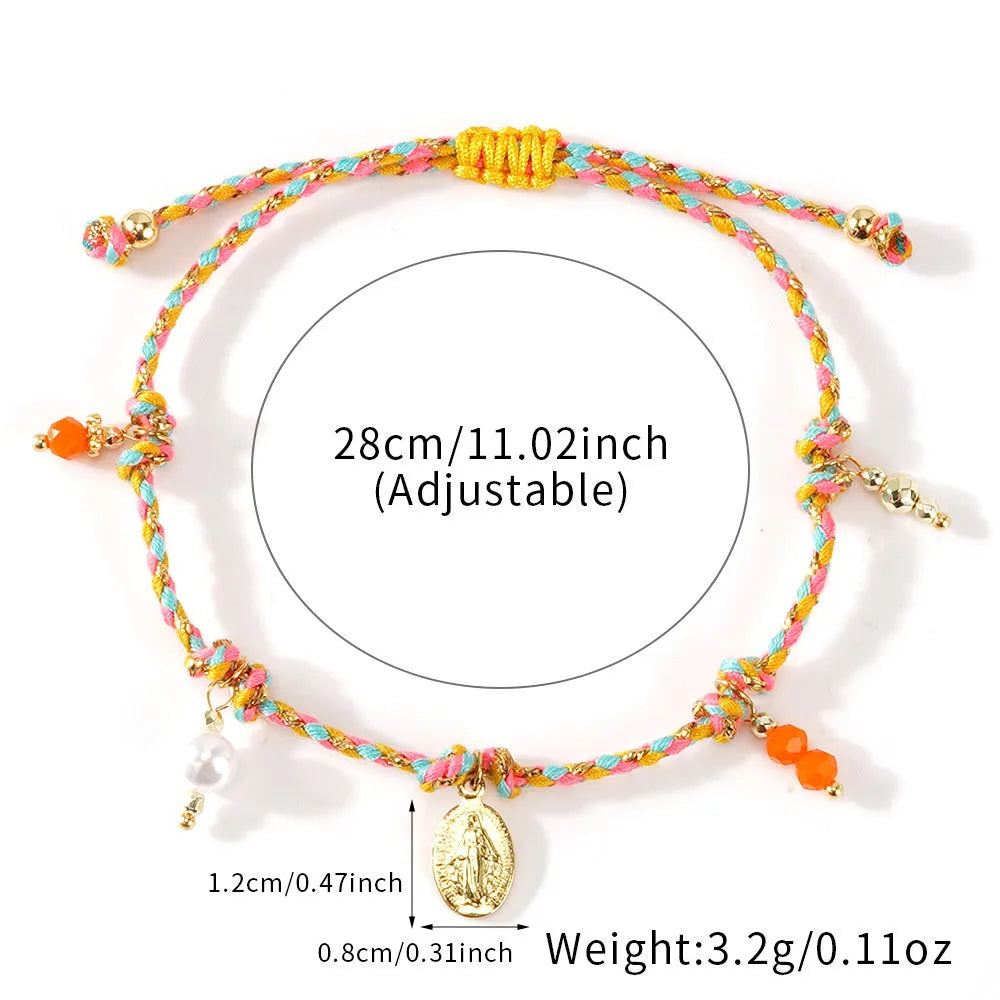 Close-up of a colourful hand-woven braided rope bracelet with a carrying strap tag on a woman's wrist.