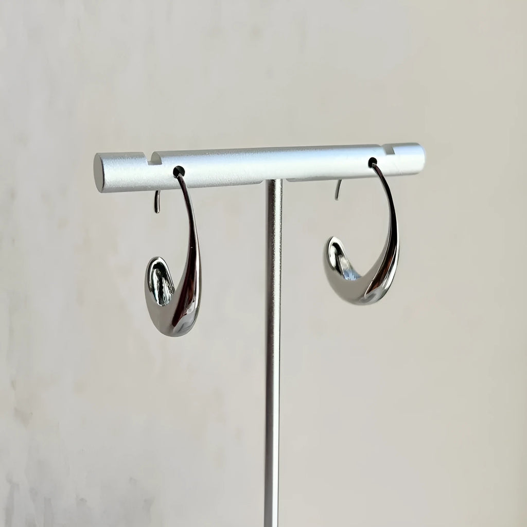 Gold electroplated alloy snake design drop earrings on a neutral background