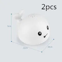 White and blue electric whale bath toy spraying water with lights on a base.