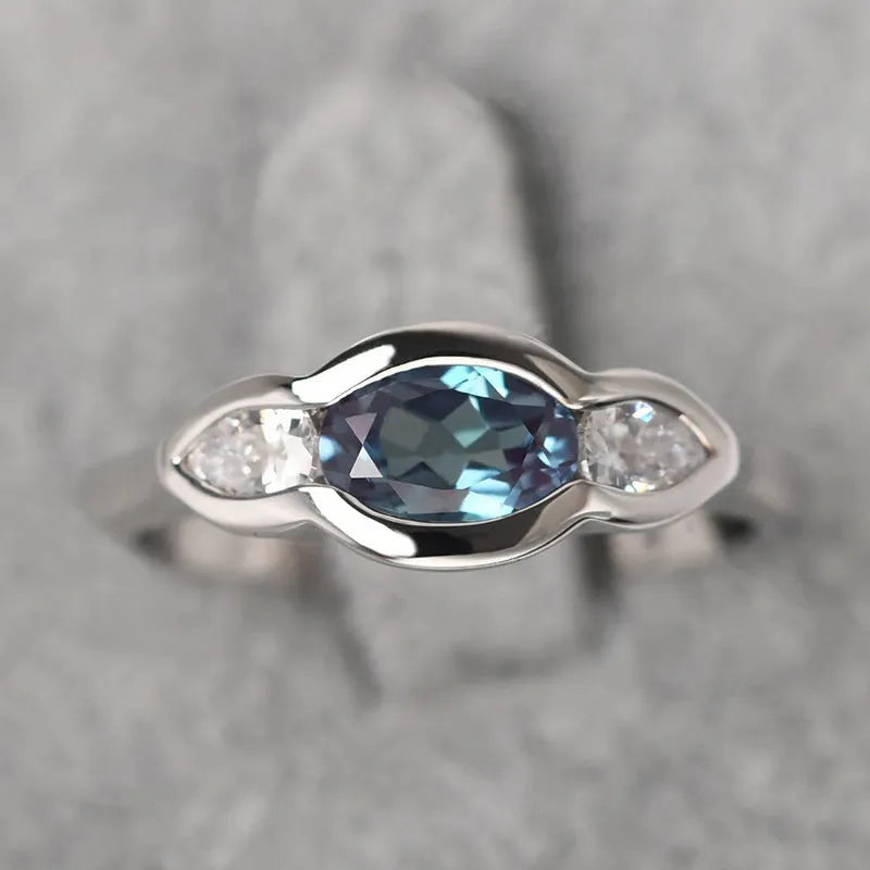 Women's geometric ellipse ring in white gold tone with inlaid zircon detailing, showing contemporary design
