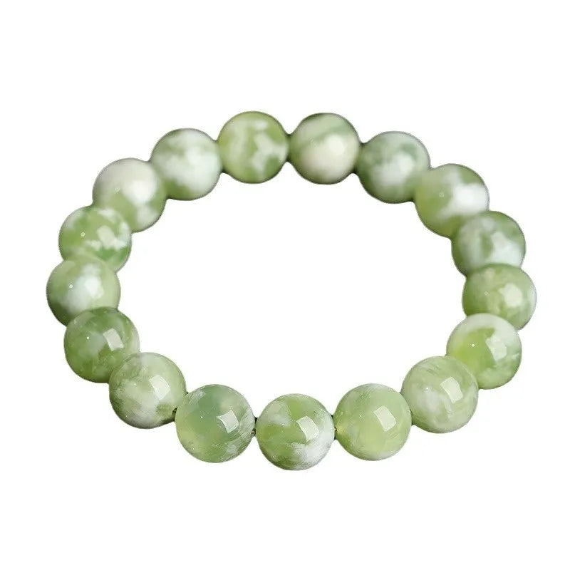 Green milk-in-water Xiuyan jade bracelet with polished geometric beads on white background