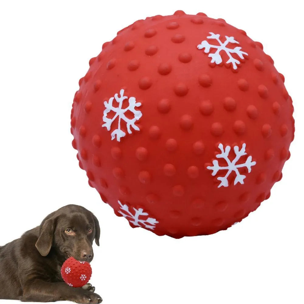 Red dog toy ball with snowflake print pattern, 7cm diameter, bouncing on grass