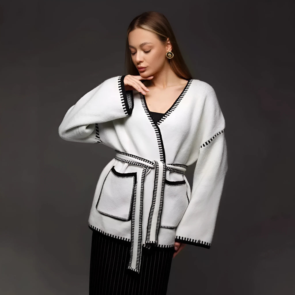 Loose knit camel coloured cardigan sweater with long sleeves on a hanger