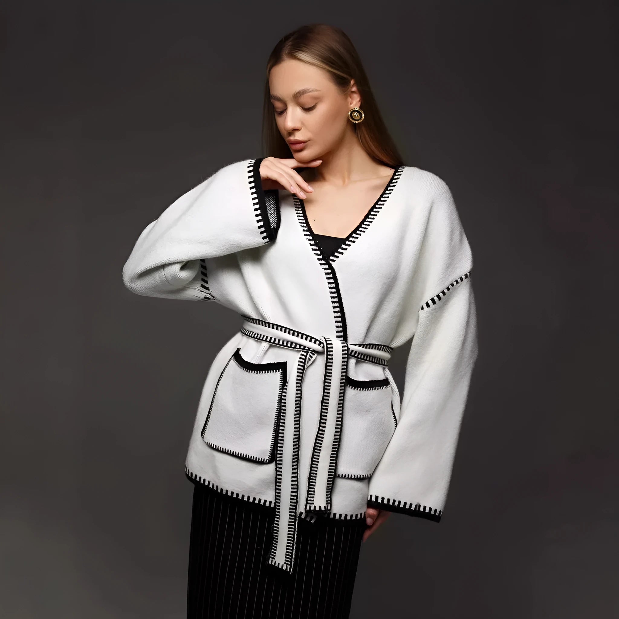 Loose knit camel coloured cardigan sweater with long sleeves on a hanger