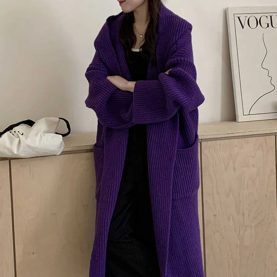 Women's loose grey hooded cardigan coat with raglan sleeves on a hanger