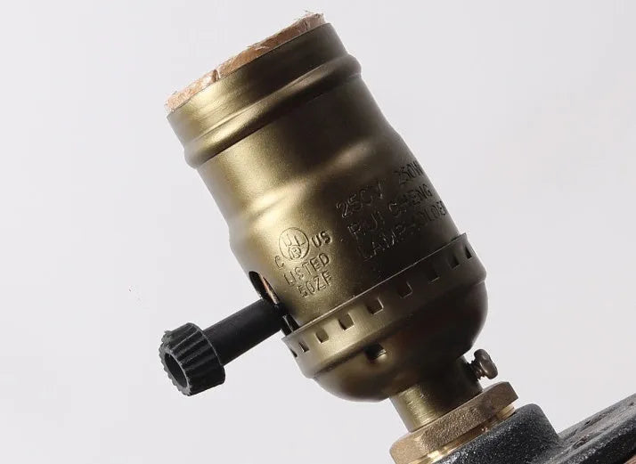 Compact wooden and iron water pipe design table lamp on a table.