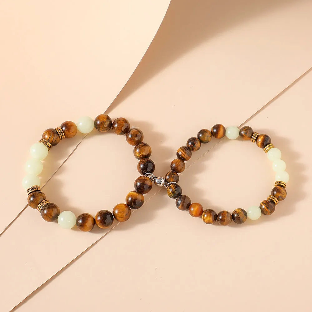 Amber Y552 luminous geometric couple bracelet on dark background showing glow effect