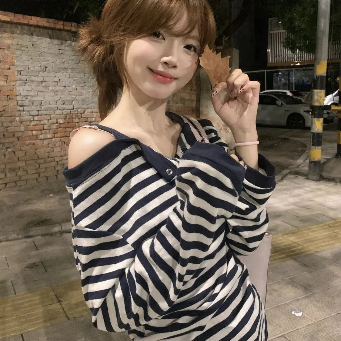 Dark blue women's oversized long-sleeve T-shirt with stripes, buttons, and embroidery details.