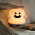 Silicone night light LED touch sensor lamp for kids bedroom in pink, showing soft glow on a bedside table