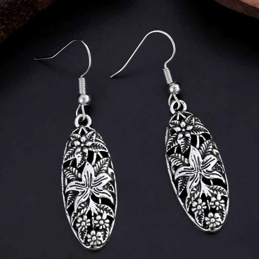 Pair of silver-tone retro hollowed out long water droplet drop earrings on light background