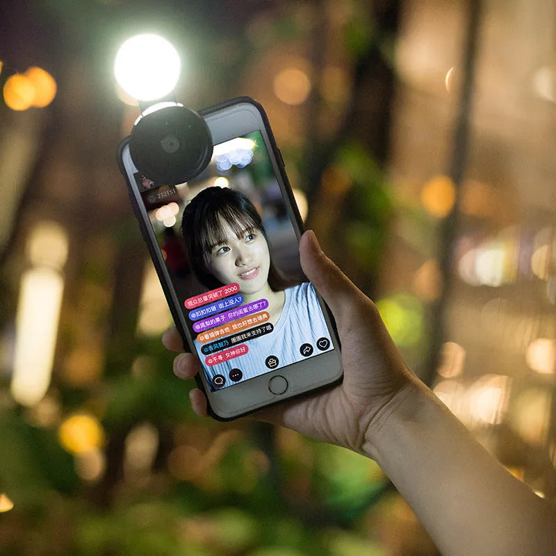 External mobile phone camera lens with wide angle and colourful light effects, black model clipped onto smartphone