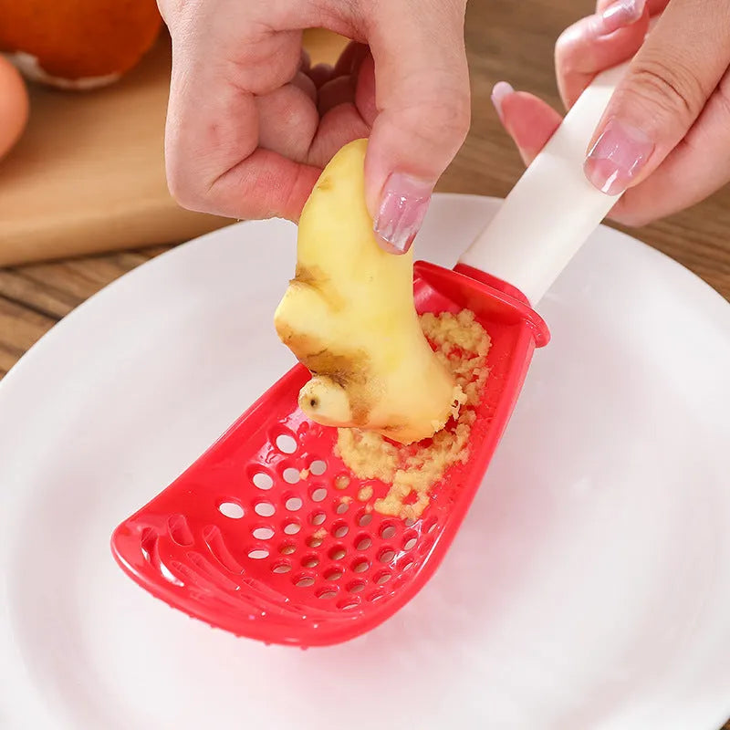 Multifunctional slotted grinding cooking spoon in red plastic with half-enclosed head and serrated edge