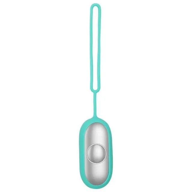 Hand-held micro-current sleep aid device in grey, with round button and micro USB port, on a desk