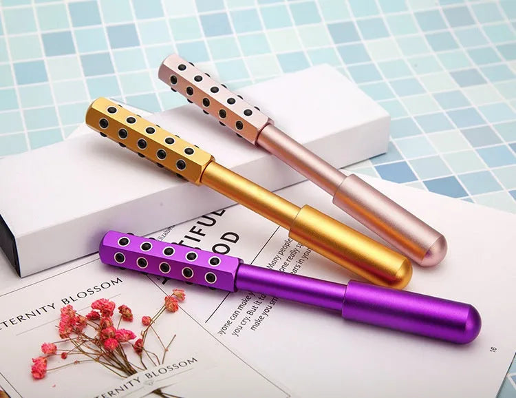 A handheld purple germanium particle facial massage roller on a white background.