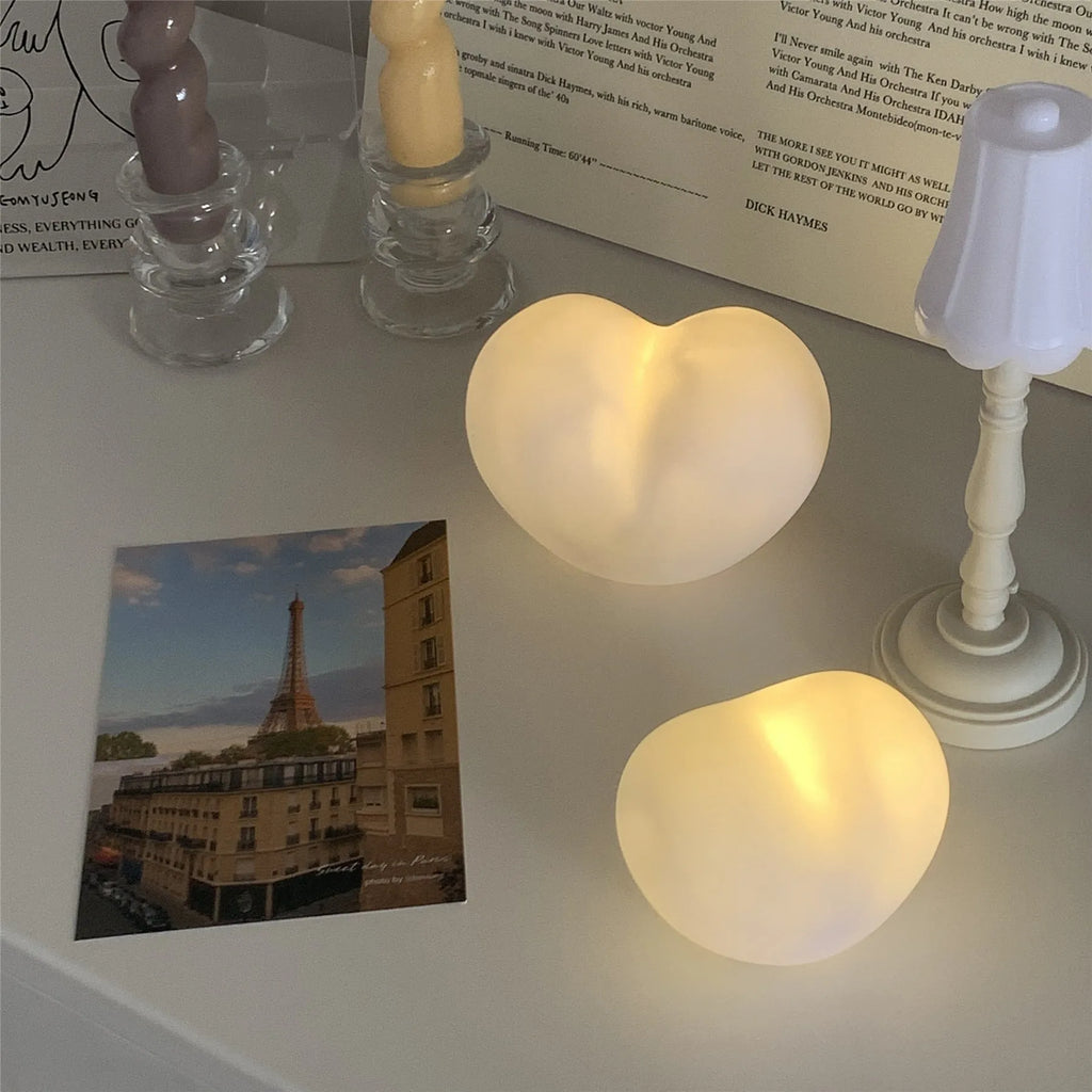 White or pink vinyl love heart atmosphere lamp in small or large size on a table.