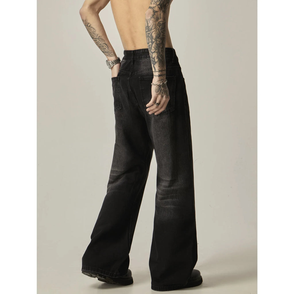 Man's black loose-fit straight-leg jeans with a retro style on a plain background.