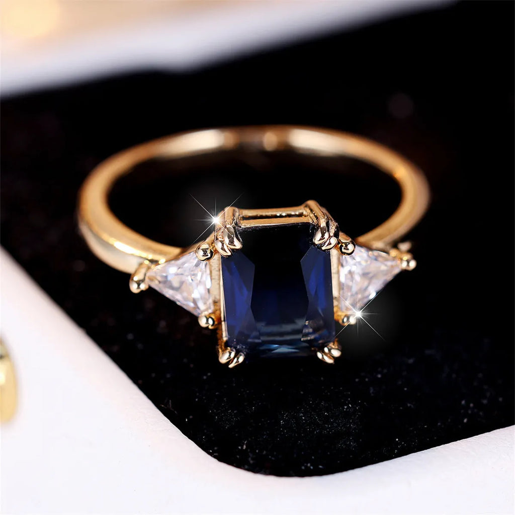 Ladies rectangular copper fashion ring in gold sapphire blue finish on finger