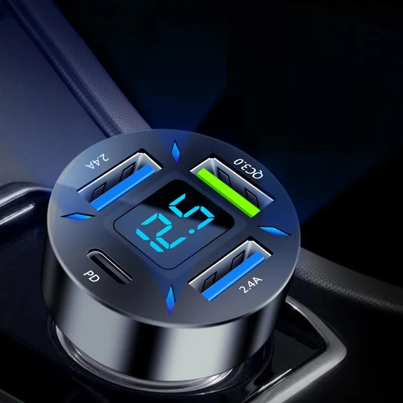 Black four-port USB car charger with digital display, plugged into a car 12V socket.