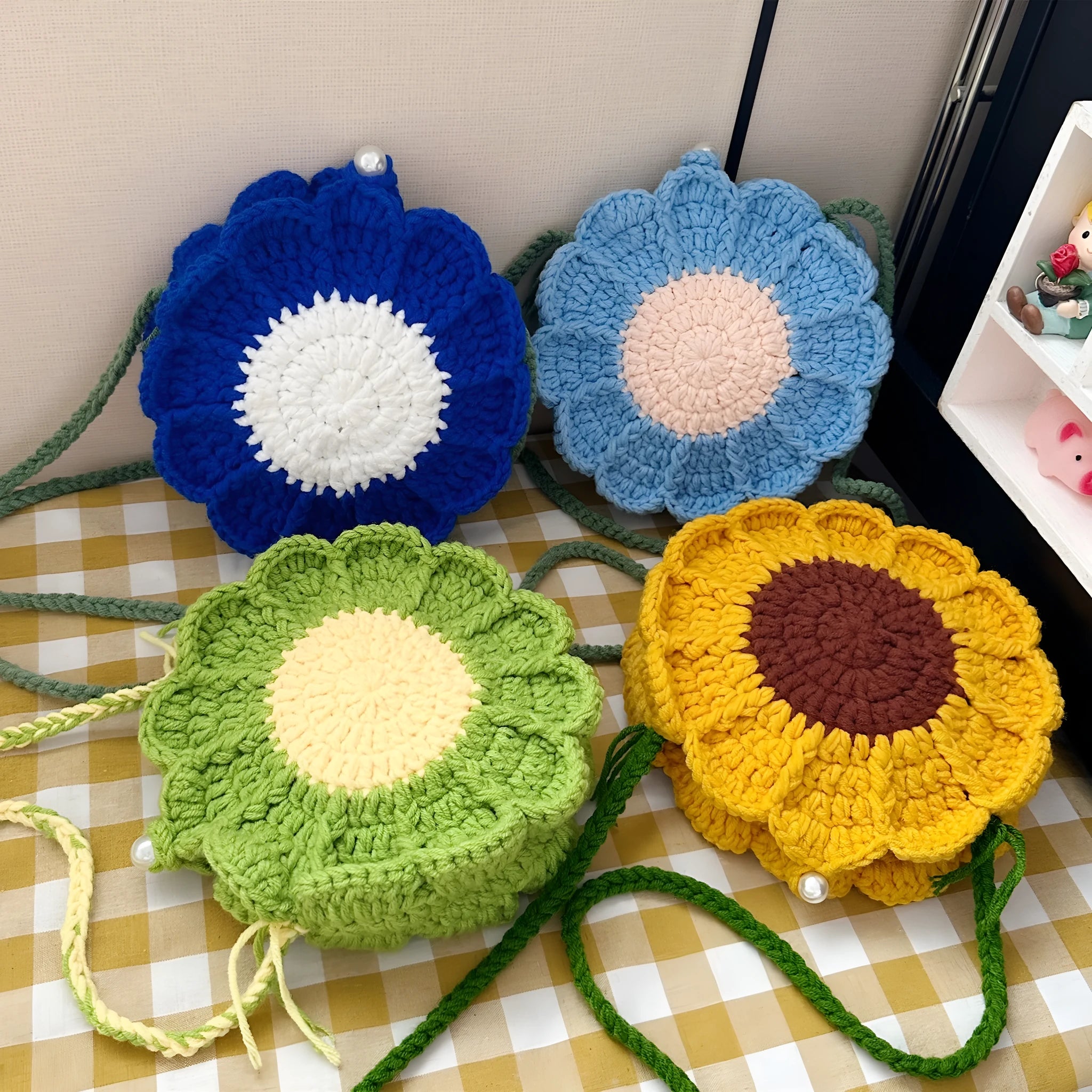 Hand-woven round wool bag with crocheted flowers and cotton lining in yellow, green, light blue, and royal blue