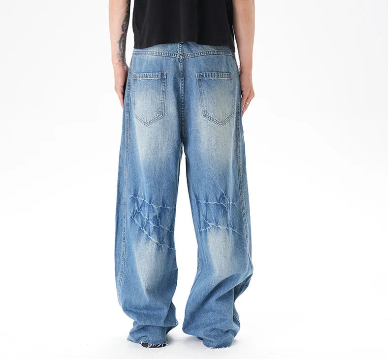 Light blue wide leg machete jeans with vintage washed denim finish, zip-fly closure, cut wash effect