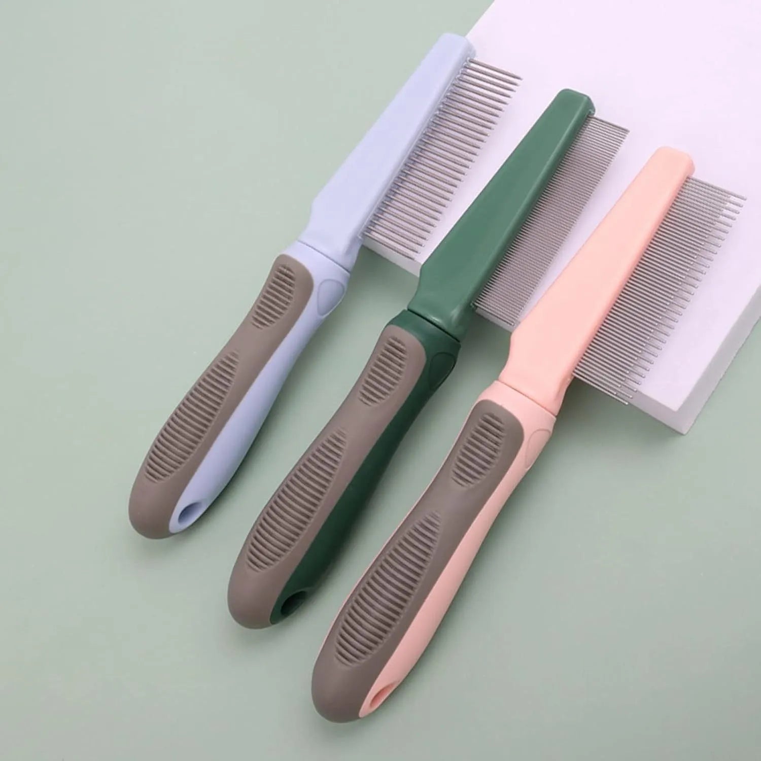 Pet detangler comb with round smooth teeth and rubber handle, available in blue or pink, for cat and dog grooming