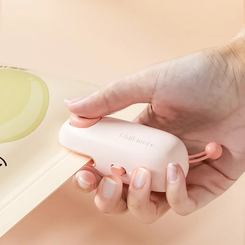 Mini rechargeable bag sealer in coffee bear design sealing a plastic snack bag on a table