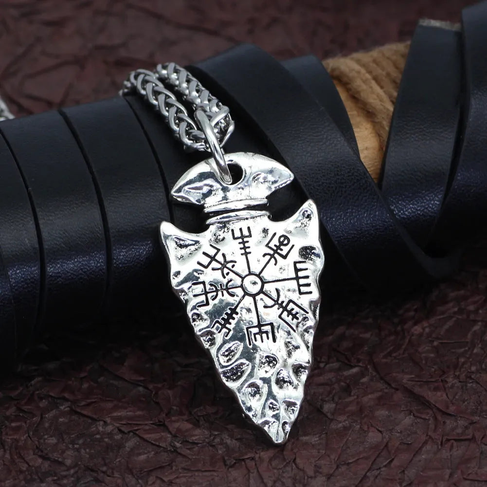 Alloy compass pendant necklace with twisted chain on a flat surface showing silver finish