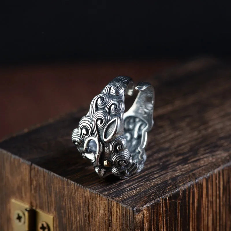 Silver open-style ring with detailed domineering jibeast animal pattern and diamond accents