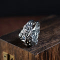 Silver open-style ring with detailed domineering jibeast animal pattern and diamond accents