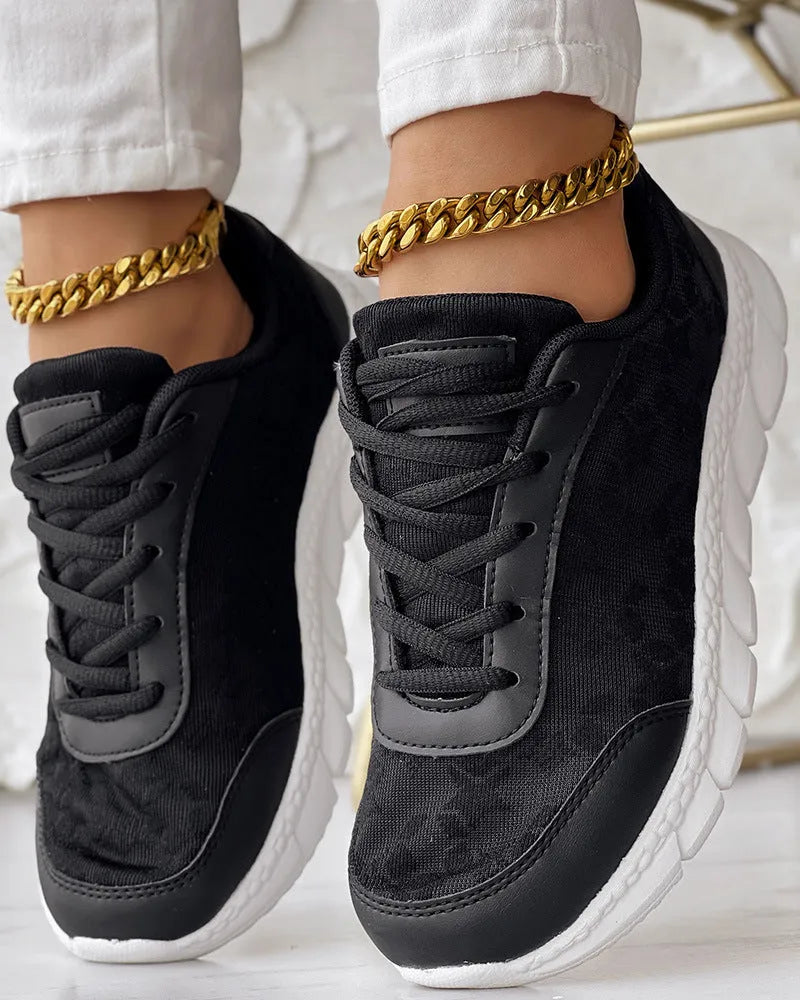 Women's white canvas casual sports shoes with a round toe and flat soft sole on a plain background.