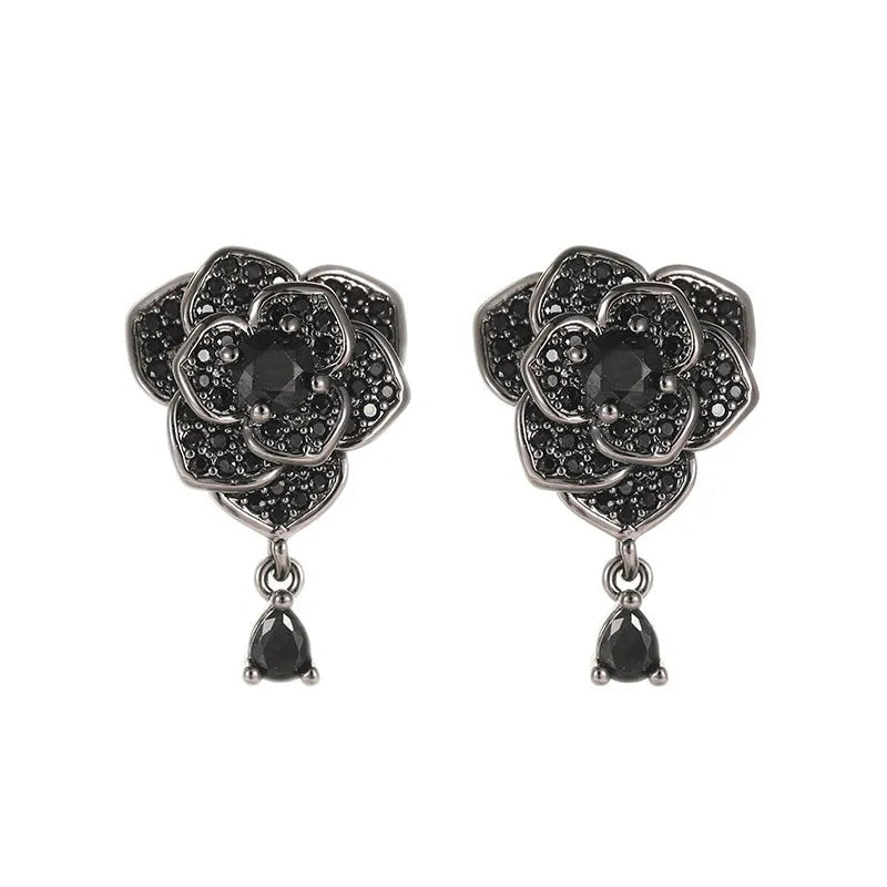 Black rose zircon inlaid stud earrings with 18K gold plated copper flower shape on white background