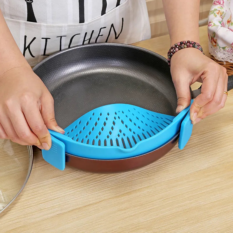 Silicone clip-on pot strainer with uniform hollow design in Red, attached to a stainless steel pot rim