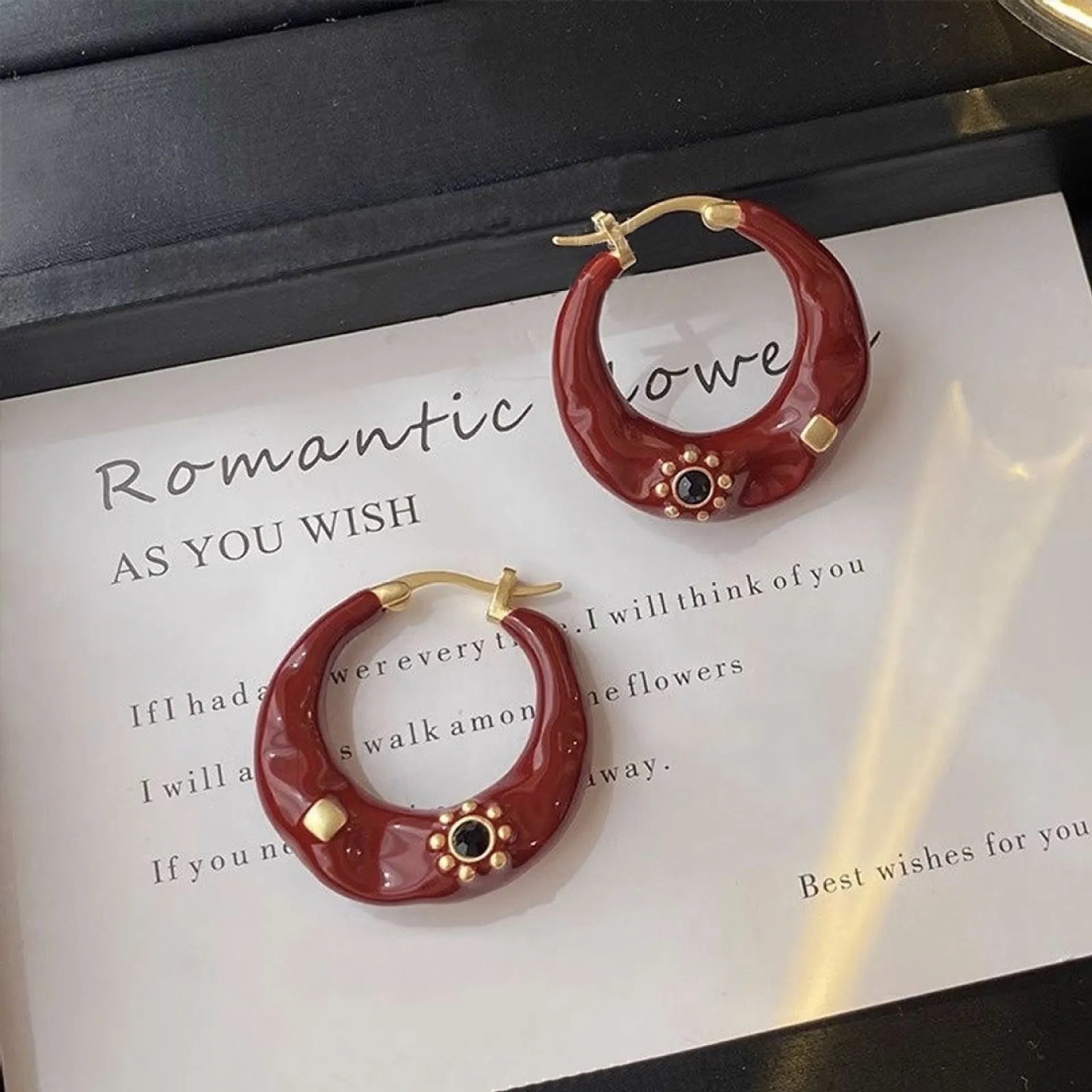 Retro style ear studs with dripping oil finish and rhinestone detailing in black and red colours