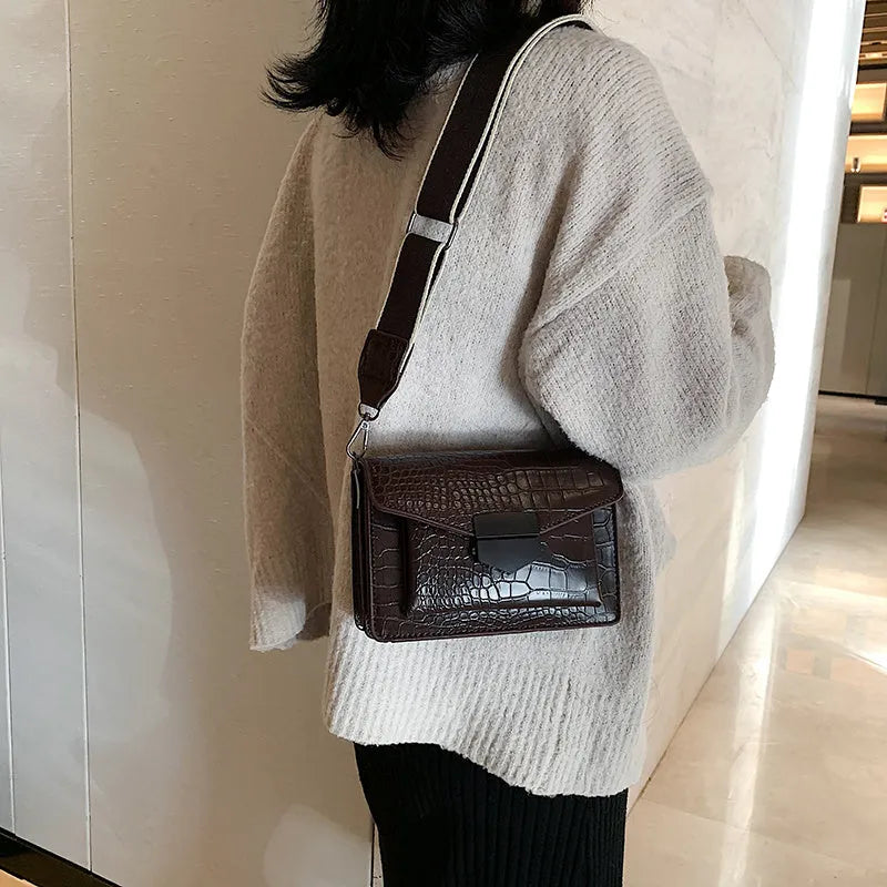 Vintage-style women's crossbody bag in PU leather, shown in black, with adjustable strap.
