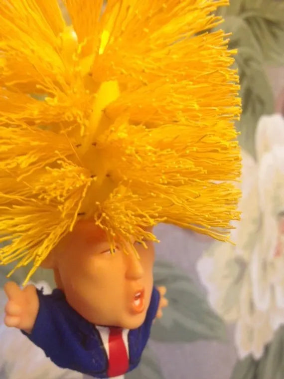 Yellow plastic Donald Trump toilet brush with handle slot, 40cm length, on white background