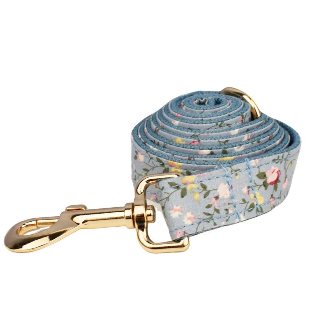 Blue floral dog collar with matching bow accessory on white background