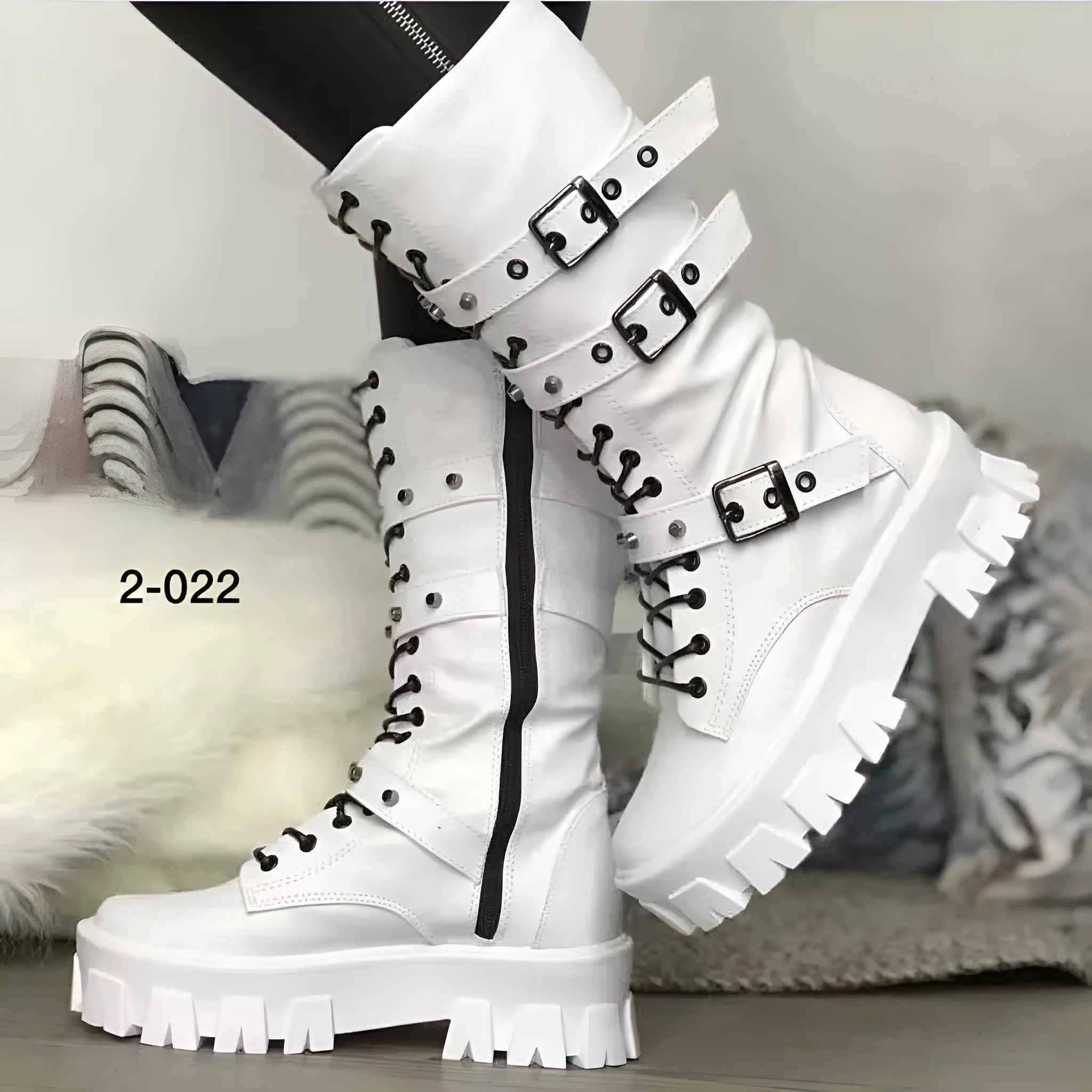 Women's black knee-high boots with metal buckle straps and a side zipper closure.
