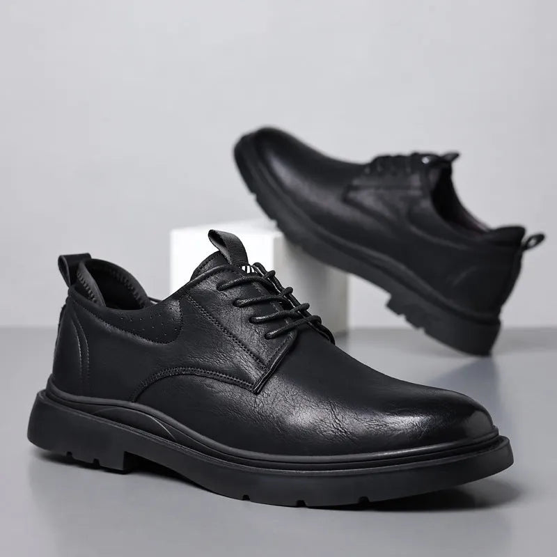 Men's black and brown leather shoes with rubber sole and sewn detailing on a white background.