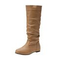 Women's black slip-on flat ankle boots with round toe and high shaft on a neutral background.