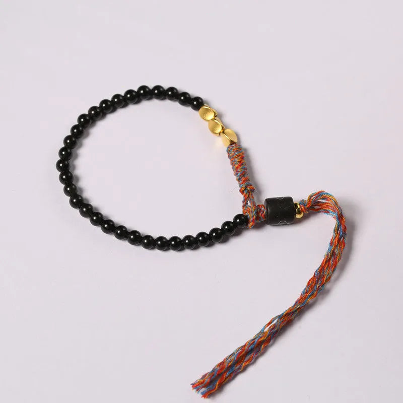 Obsidian coloured hand-woven leather strap bracelet with adjustable fastening on a wrist.