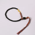 Obsidian coloured hand-woven leather strap bracelet with adjustable fastening on a wrist.